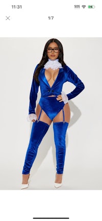 a woman is posing in a blue velvet suit